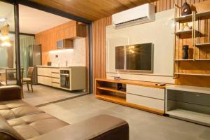 a living room with a television and a kitchen at Atlântico Collection in Rio de Janeiro