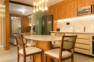 a kitchen with a table and chairs and a refrigerator at Atlântico Collection in Rio de Janeiro