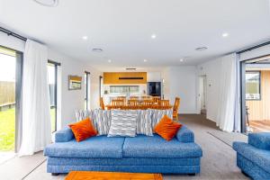 a living room with a blue couch and a table at Elegant, Executive Retreat in Methven