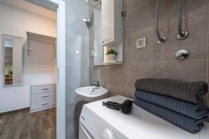 a bathroom with a sink and a toilet and a mirror at !PROMO! Giallo Modern Studio-Free Private Parking-Fast WI-FI in Novi Sad