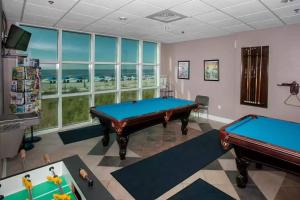 two pool tables in a room with windows at Crystal Shores West 1101 in Gulf Shores