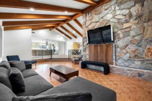 塞多纳Unrivaled views Large uptown home wIth SwimSpa and Sauna的客厅设有石墙和电视