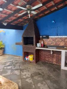 a kitchen with a brick oven in a room at Casa de praia com piscina e área gourmet in Peruíbe