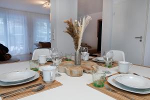 - une table à manger avec des assiettes et des verres dans l'établissement Vallhouse - Massage, Sauna, Darts, Switch & mehr, à Vallendar