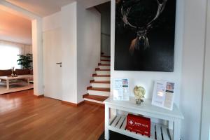 uma sala de estar com uma escada e uma fotografia de um veado na parede em Vallhouse - Massage, Sauna, Darts, Switch & mehr em Vallendar