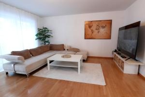 uma sala de estar com um sofá e uma mesa em Vallhouse - Massage, Sauna, Darts, Switch & mehr em Vallendar