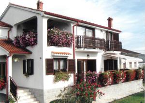 una casa blanca con flores en los balcones en Apartments Perić en Opatija