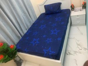 a bed with a blue sheet with stars on it at YOUR HOME in Dubai