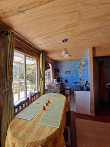 una gran mesa de madera en una habitación con cocina en cabaña hermosa vista en maicolpue playa grande, en Osorno