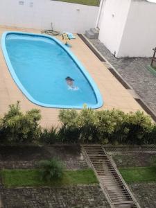 una persona nadando en una gran piscina azul en Apto familiar c/ piscina, próx as praias reg Sul en João Pessoa