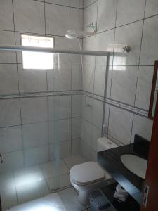a white bathroom with a toilet and a sink at Recanto WL in Olímpia