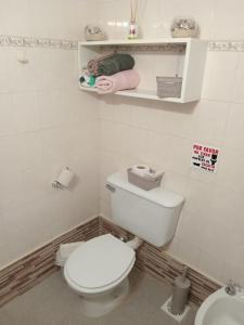La salle de bains blanche est pourvue de toilettes et d'un lavabo. dans l'établissement Monoambiente Osvaldo, à Neuquén