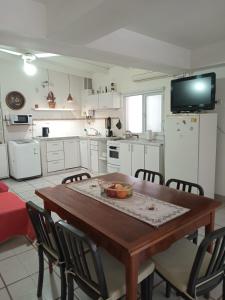 Il comprend une cuisine avec une table en bois, des chaises et une télévision. dans l'établissement Monoambiente Osvaldo, à Neuquén
