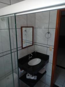 a bathroom with a sink and a mirror at Recanto WL in Olímpia