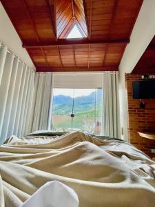 a bed in a bedroom with a large window at Valle Piemonte in Divisa