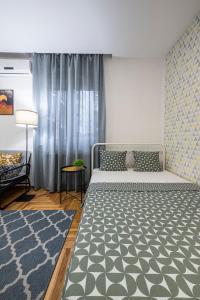 a bedroom with a bed and a blue rug at !PROMO! Giallo Modern Studio-Free Private Parking-Fast WI-FI in Novi Sad