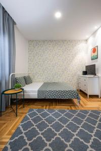 a bedroom with a bed and a table and a rug at !PROMO! Giallo Modern Studio-Free Private Parking-Fast WI-FI in Novi Sad