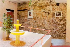 a yellow fountain in front of a brick wall at Résidence St Vincent in Collioure
