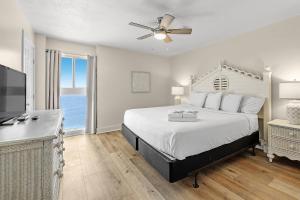 - une chambre avec un lit, un ventilateur de plafond et une télévision dans l'établissement Edgewater West 93, à Gulf Shores