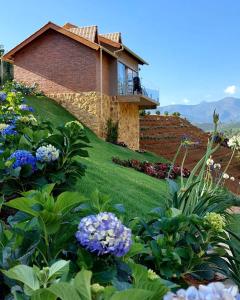 a house on top of a hill with flowers at Valle Piemonte in Divisa