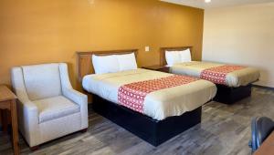 um quarto de hotel com duas camas e uma cadeira em Regency Inn Hondo em Hondo
