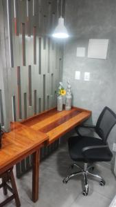 een houten tafel met een zwarte stoel in een kamer bij Studio Girassol in Florianópolis