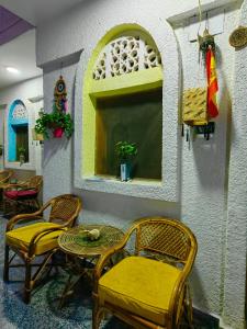 une chambre avec des chaises, une table et une fenêtre dans l'établissement Gina Motel Dahab, à Dahab