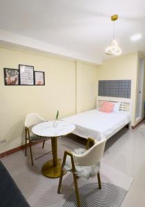- une chambre avec un lit, une table et des chaises dans l'établissement Studio Guest Suite Near The New EVRMC Hospital & San Juanico Bridge Tacloban City, Leyte, Philippines, à Tacloban