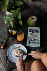 a person eating a plate of food on a table at Pousada Lagoa in Caraíva