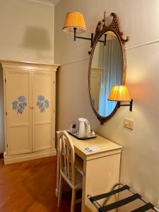 a table with a mirror and a tea kettle on it at Lilium Boutique Hotel in Rome
