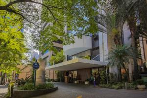 um edifício numa rua com árvores em frente em Flat Executive Transamerica Faria Lima Itaim em São Paulo