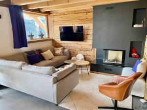 ein Wohnzimmer mit Couch und Kamin in der Unterkunft Chalet de standing avec jacuzzi et ski-room, 5 chambres - FR-1-505-199 in Notre-Dame-de-Bellecombe