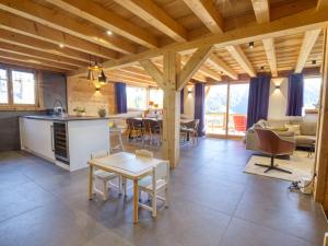 eine Küche und ein Wohnzimmer mit Tisch und Stühlen in der Unterkunft Chalet de standing avec jacuzzi et ski-room, 5 chambres - FR-1-505-199 in Notre-Dame-de-Bellecombe