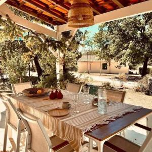 einen Holztisch mit Weingläsern auf einer Terrasse in der Unterkunft Etang Vallier Resort Brossac in Brossac