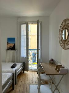 um quarto com uma cama, uma mesa e uma janela em Grande maison de pêcheur - centre de Trouville em Trouville-sur-Mer