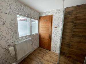 a bathroom with a window and a door with graffiti at Chalupa Bob a Bobek in Horní Bečva