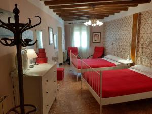 - une chambre avec 2 lits et des draps rouges dans l'établissement CASA DOMPER VIVIENDA DE TURISMO RURAL, 