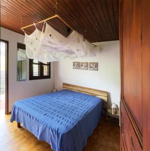 a bedroom with a bed with a blue comforter at Villa Vivi in Gros-Morne