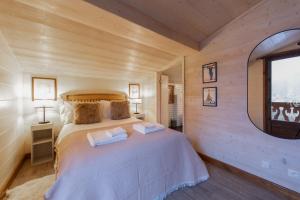 a bedroom with a large bed in a wooden room at Chalet Figue in Morzine