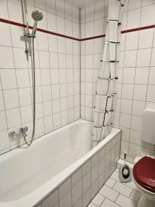 a white bathroom with a tub and a toilet at Einfaches ruhiges Apartment in Laichingen