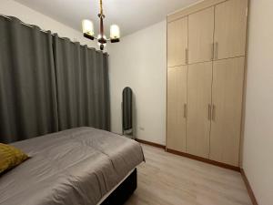 a bedroom with a bed and a dresser and curtains at Waterfalls Manor in Lusaka