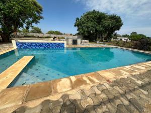 a swimming pool with blue tiles in a yard at Waterfalls Manor in Lusaka