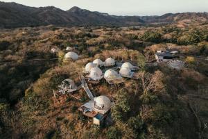 an overhead view of a group of domes in a field at Alaya Panama in Playa Venao