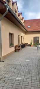 a courtyard of a building with benches on it at Penzion pod Kozákem in Mikulov