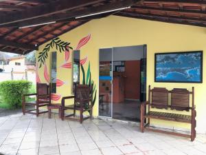 uma casa com três cadeiras e uma parede com um quadro em Pousada Ana e o Mar em Ubatuba