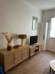 uma sala de estar com televisão num armário de madeira em Grande maison de pêcheur - centre de Trouville em Trouville-sur-Mer