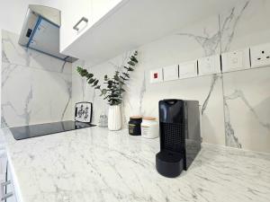 een keuken met een wit marmeren aanrecht met een zwart toetsenbord bij 1BD Beach Apartment in Paphos City +4 foto's