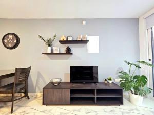 een woonkamer met een tv en een tafel bij 1BD Beach Apartment in Paphos City