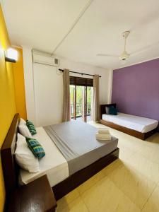 a bedroom with two beds and a window at Ravan Resort Tangalle in Tangalle