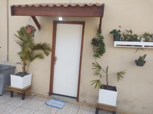 uma porta aberta com vasos de plantas numa parede em QUARTO CONFORTAVEL COM GARAGEM em Holambra